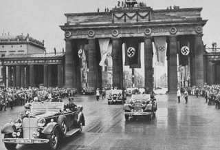 Adolf Hitler passes through the Brandenburg Gate on his way to the opening ceremony of the Olympic Games.